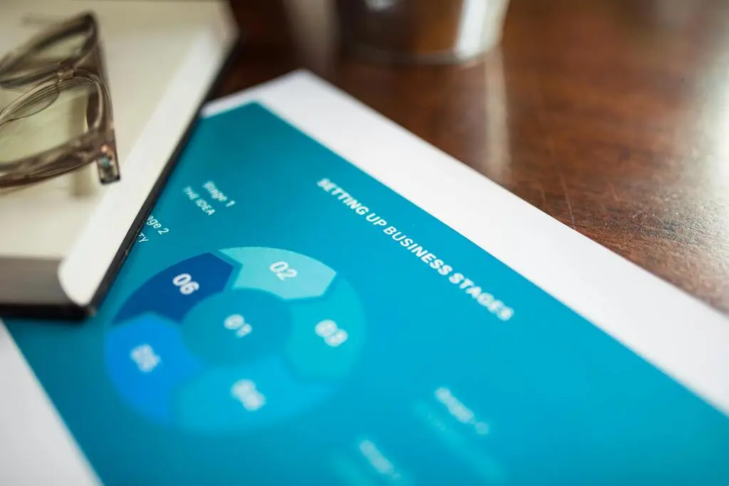 Sheet with a pie chart on a light wooden table